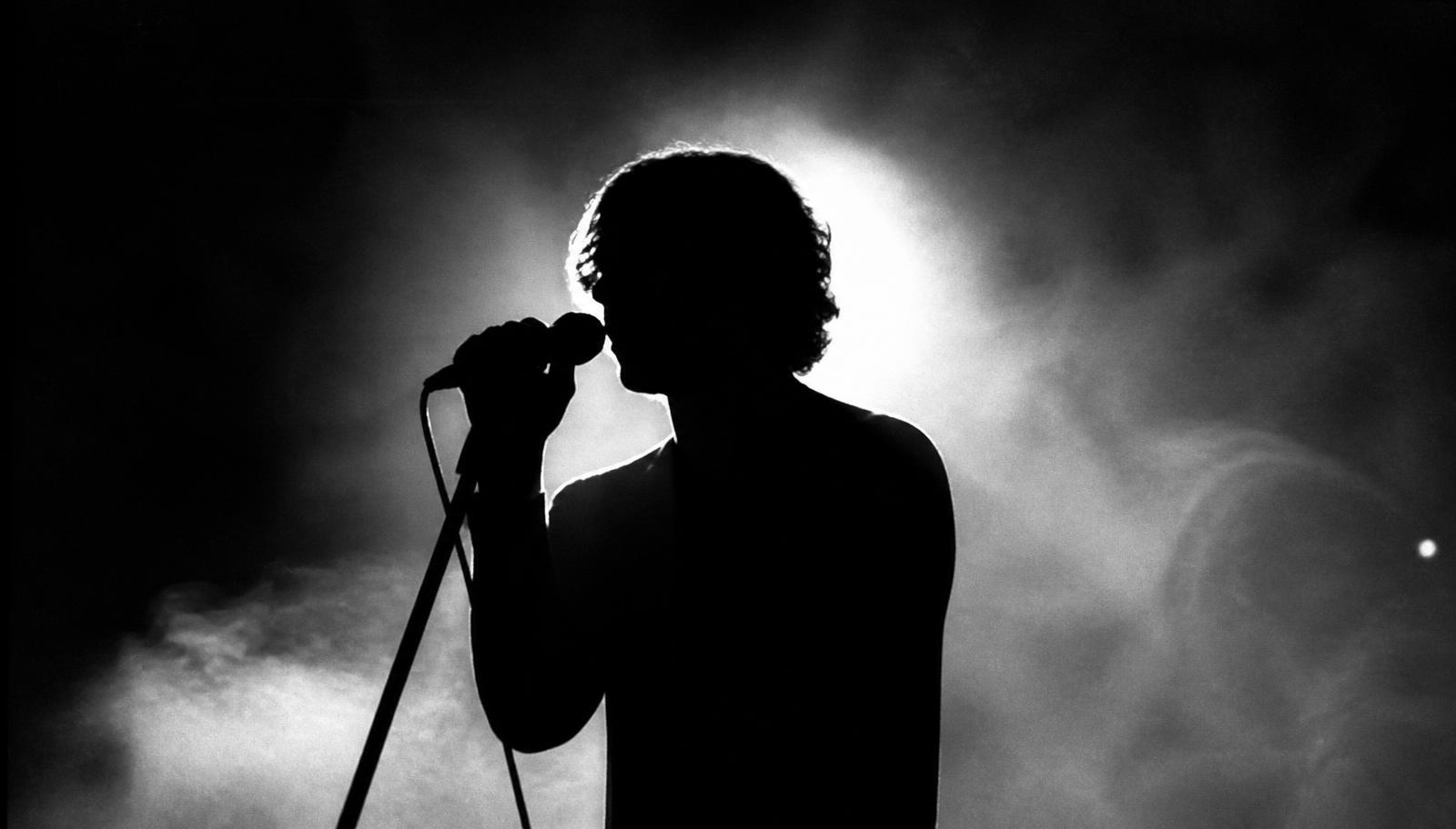 Silueta de una persona cantando a contraluz, en blanco y negro